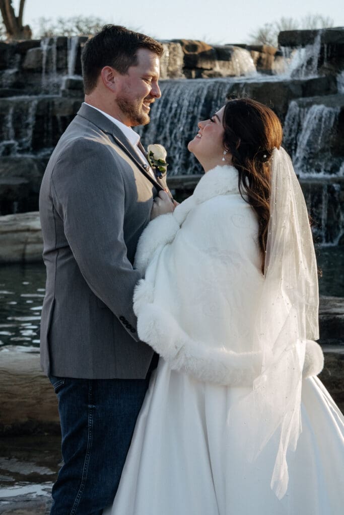 Bride and groom face to face while smiling at each other